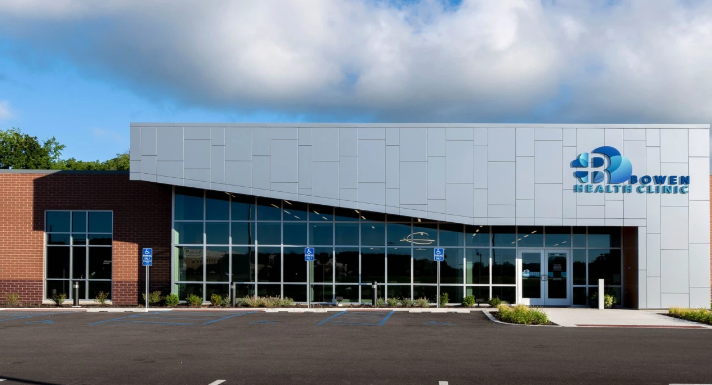 Photograph of Bowen health clinic building with large glass windows and a blue logo